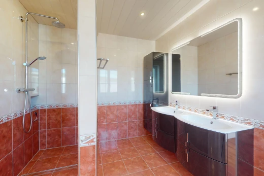 salle de bain avec douche, carrelage, mur carrelé, meuble-lavabo, et miroir