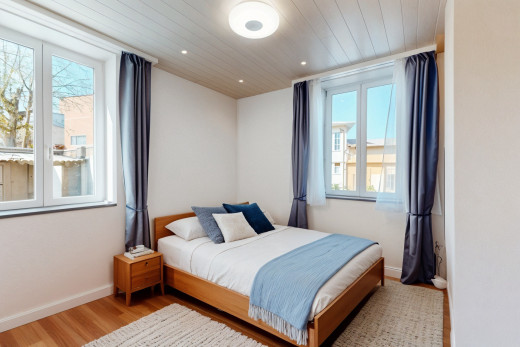 chambre avec plancher de bois et lumière naturelle