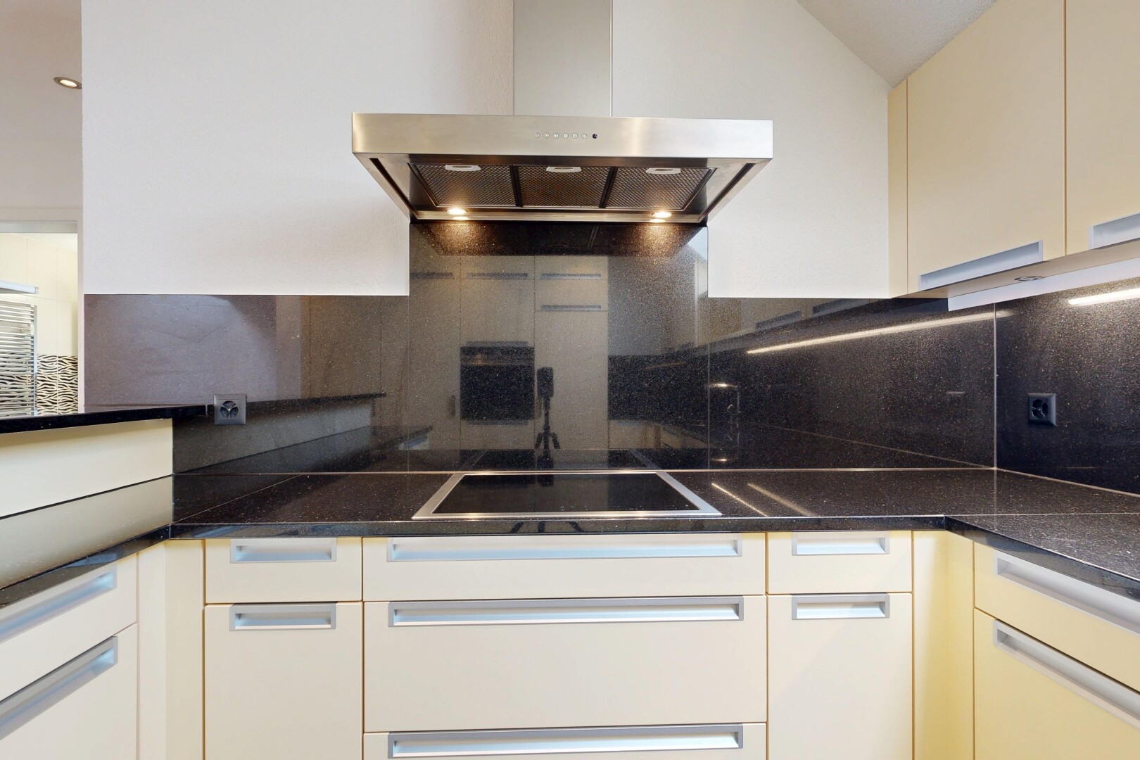 küche mit dunstabzugshaube, dark countertops, küchenrückwand beim herd, küchenrückwand beim Herd, und inside property