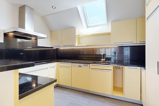 kitchen featuring cream cabinetry, dark stone counters, backsplash, and open shelves