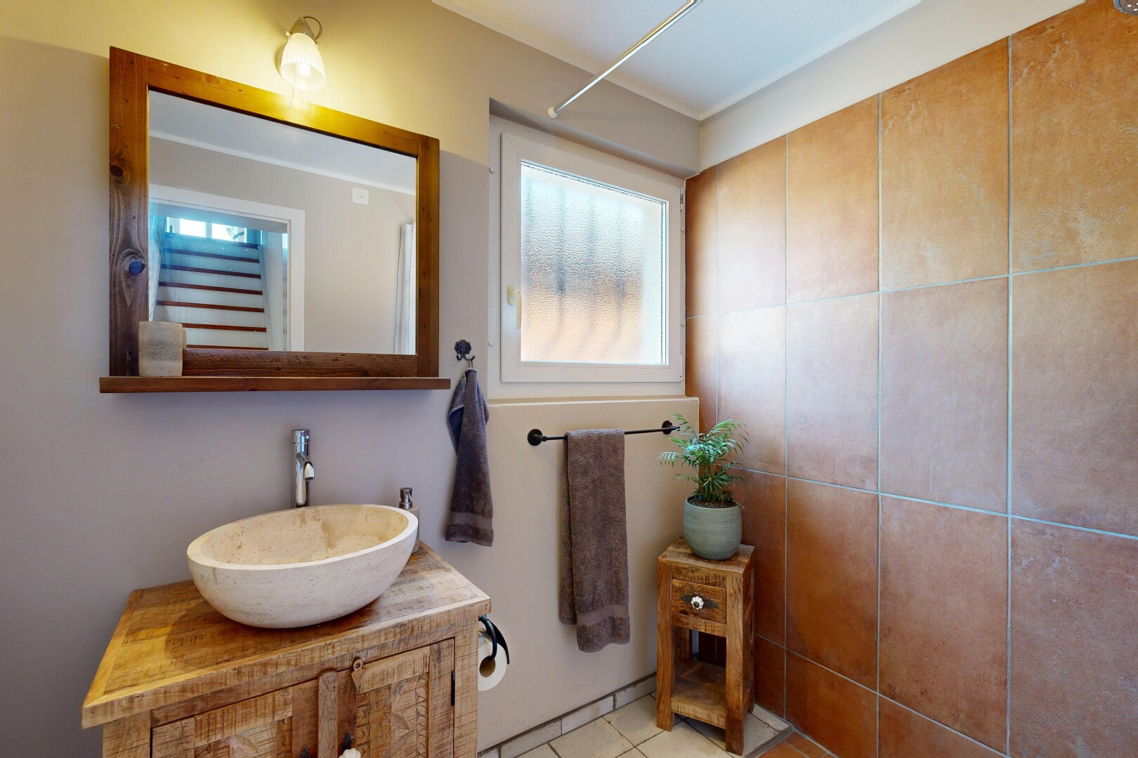 bad mit spiegel, schminktisch, waschbecken, inside property, und natürliches licht