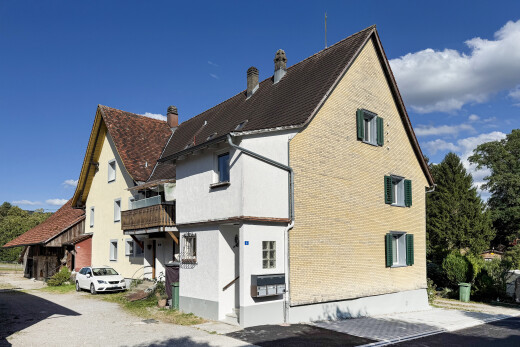 view of home featuring a chimney and a balcony