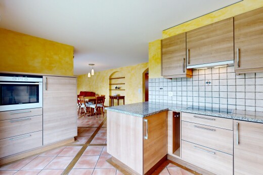 kitchen featuring light brown cabinets, light tile patterned flooring, and light stone countertops