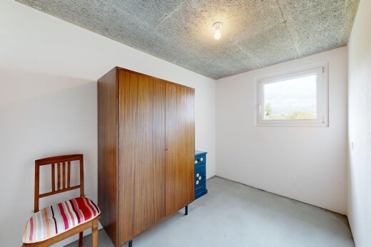 room featuring a closet, finished concrete flooring, and a textured ceiling