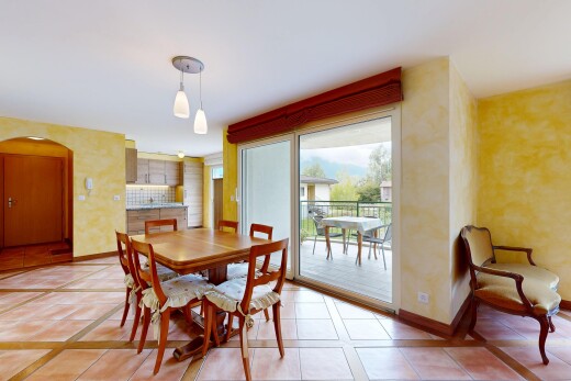 dining area featuring arched walkways, light tile patterned flooring, and inlaid floor details