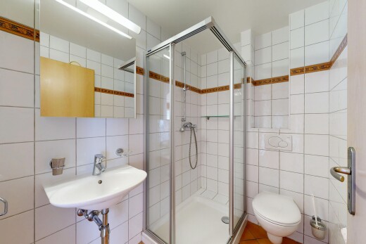full bathroom with tile walls and a stall shower