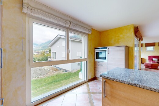 kitchen with light tile patterned floors, stainless steel oven, light stone countertops, and built in refrigerator
