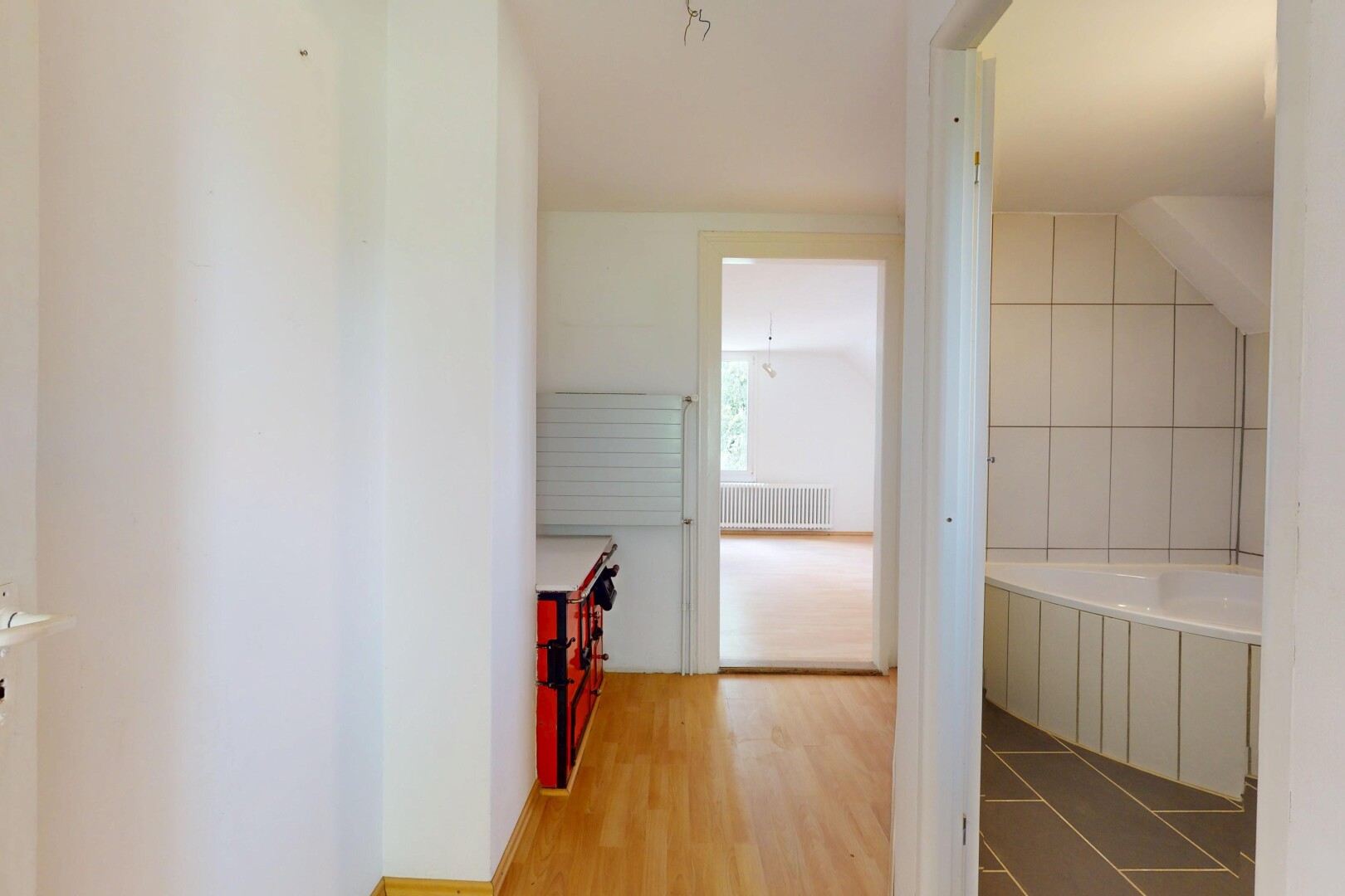 couloir avec inside property, sol en finition bois, wood finish floor, radiateur, et lumière naturelle