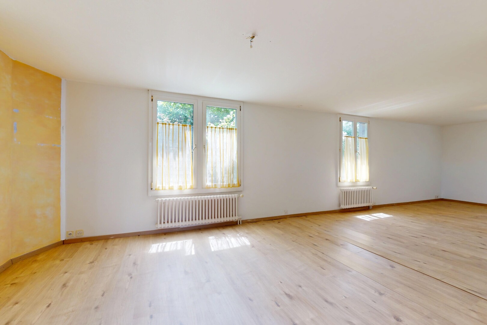pièce vide avec radiateur, lumière naturelle, natural light, inside property, et sol en finition bois