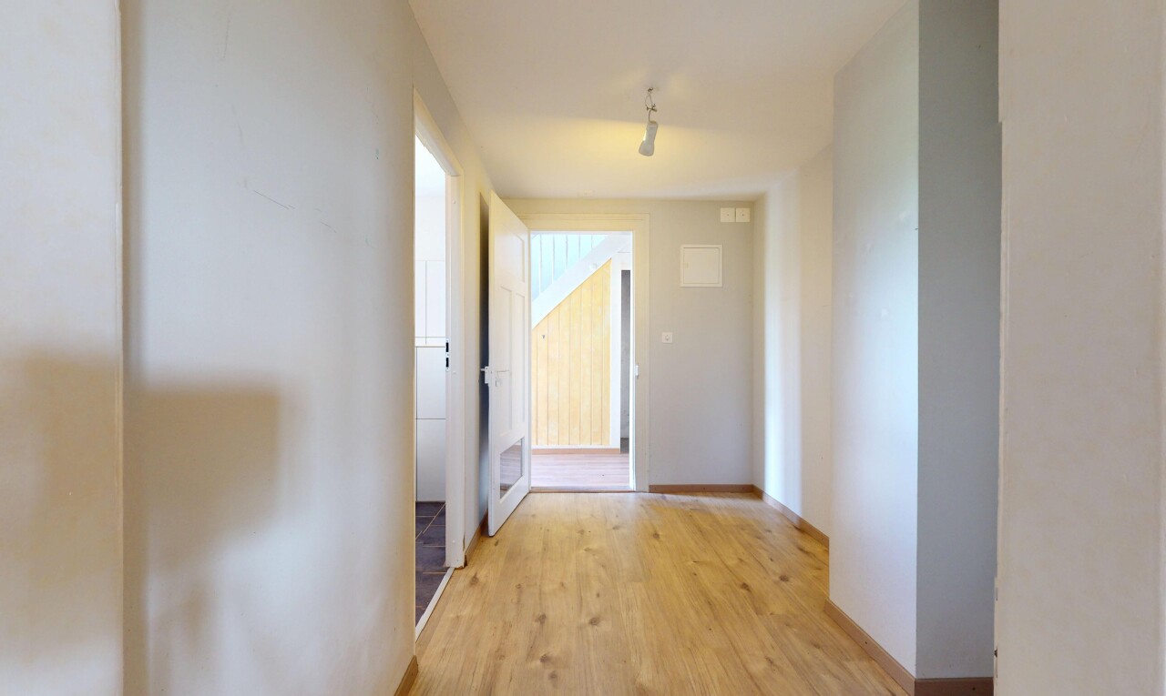 couloir avec cloison sèche, drywall, inside property, sol en finition bois, et wood finish floor