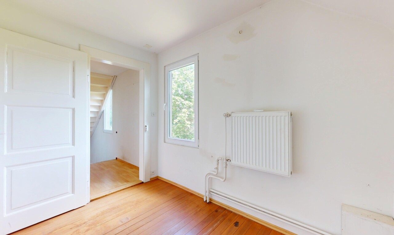 pièce vide avec radiateur, sol en finition bois, wood finish floor, lumière naturelle, et natural light