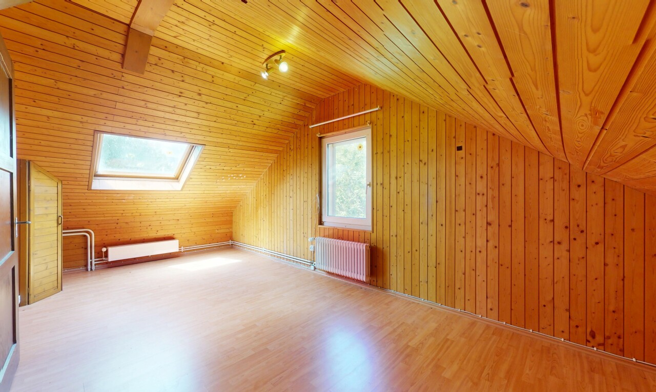 pièce vide avec radiateur, plafond voûté, vaulted ceiling, sol en finition bois, et wood finish floor
