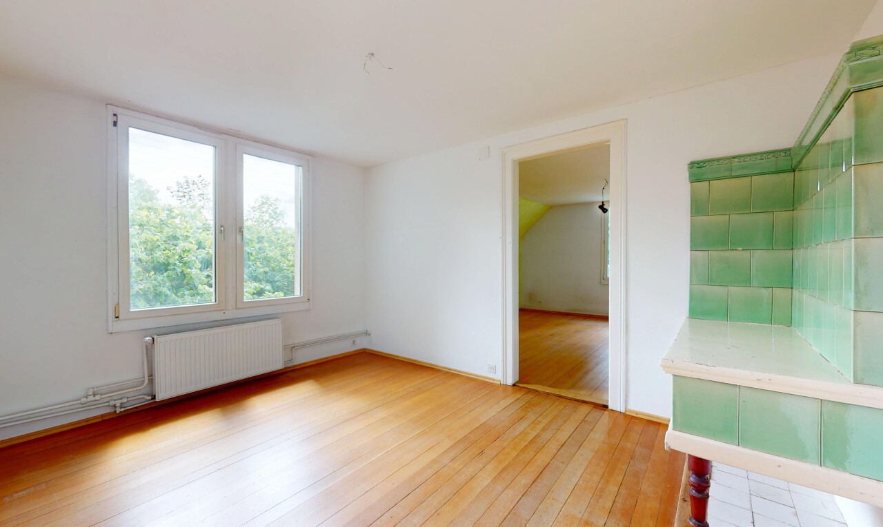 pièce vide avec radiateur, sol en finition bois, wood finish floor, lumière naturelle, et natural light