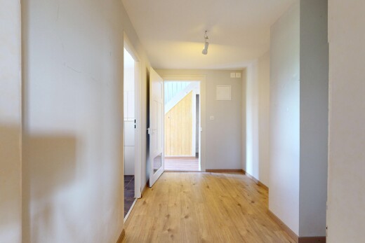 couloir avec cloison sèche, drywall, inside property, sol en finition bois, et wood finish floor