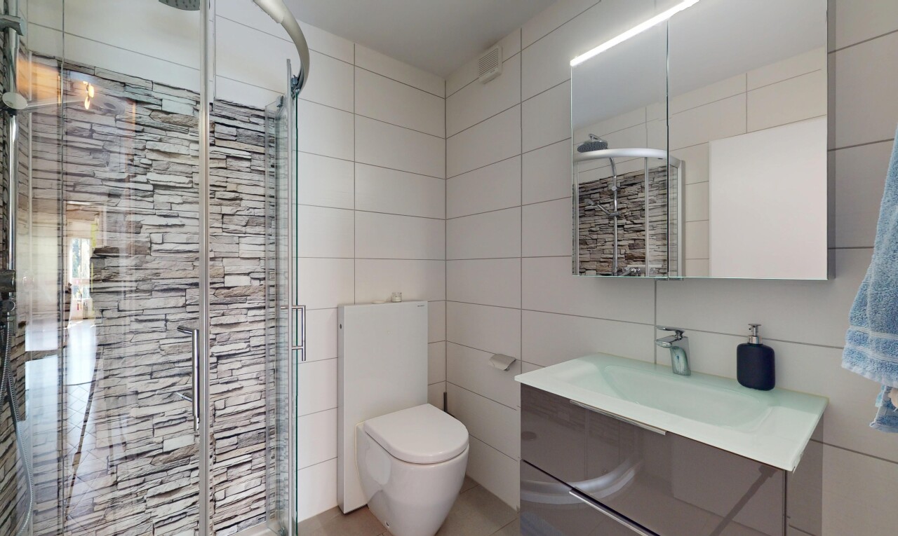 salle de bains avec mur en carrelage, tile wall, inside property, lavabo (ou coiffeuse selon le contexte), et douche