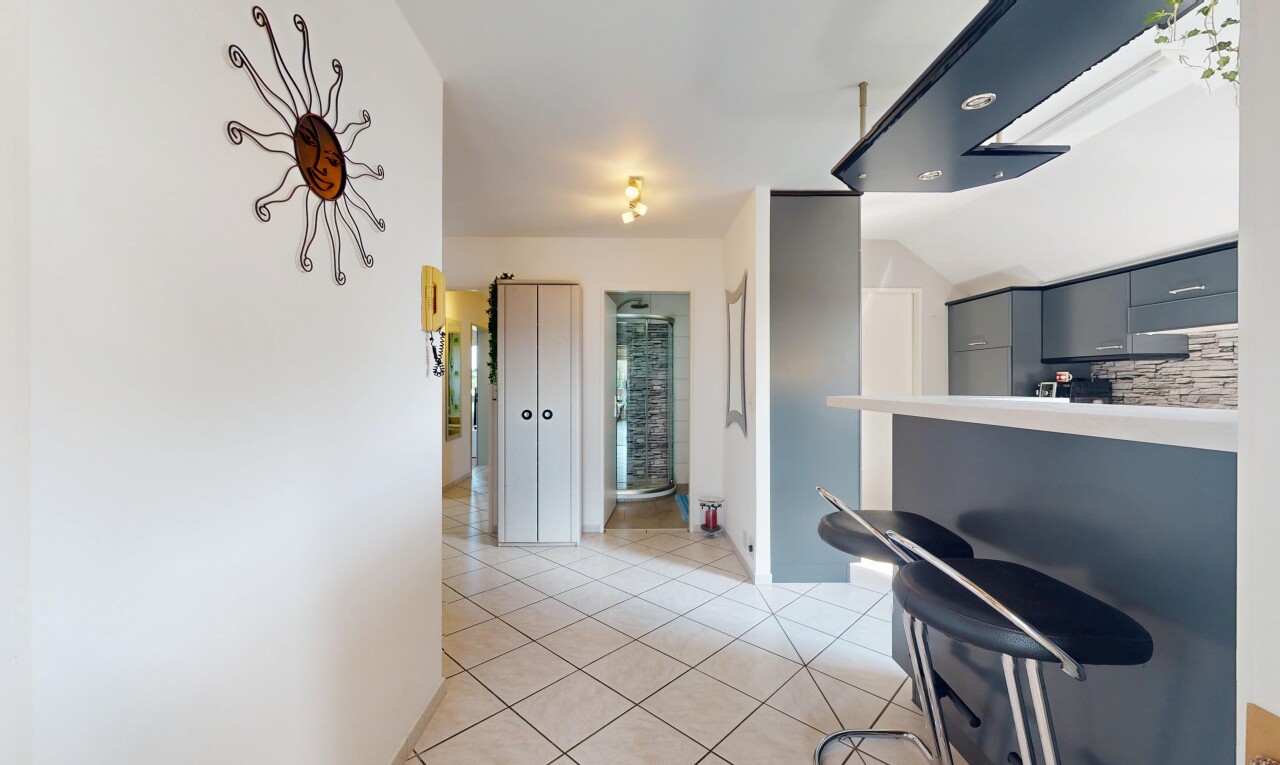 couloir avec inside property, cloison sèche, drywall, sol en carrelage, et tile floor