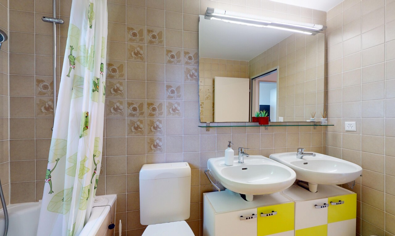 salle de bains avec mur en carrelage, tile wall, inside property, évier, et miroir