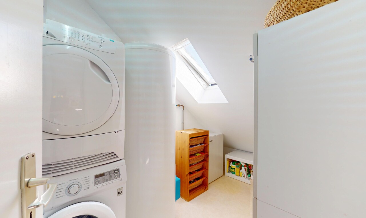 buanderie avec lave-linge et sèche-linge superposés, puits de lumière, buanderie, inside property, et lumière naturelle