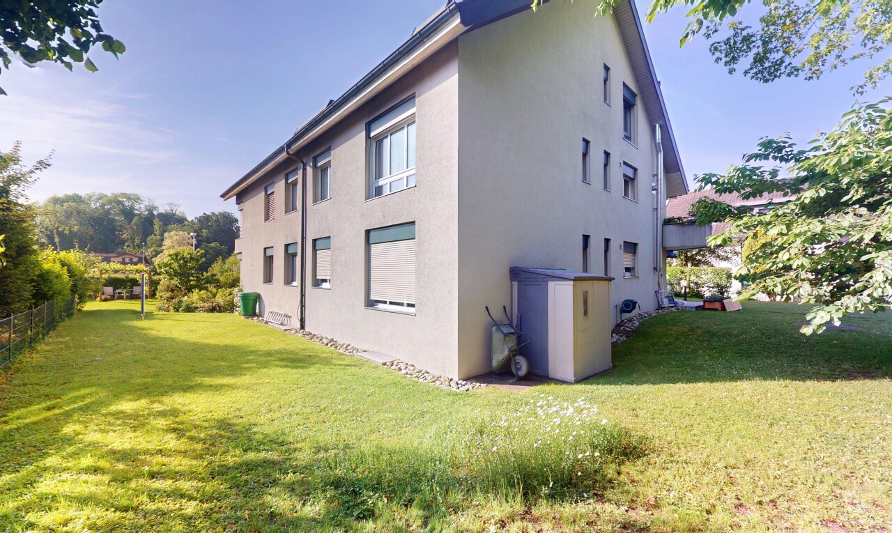 façade avec property visible, bardage en stuc, pelouse, et day time