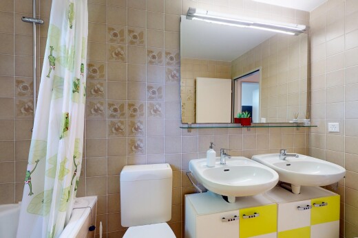 salle de bains avec mur en carrelage, tile wall, inside property, évier, et miroir