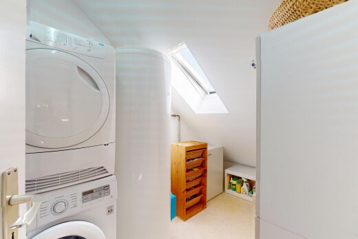buanderie avec lave-linge et sèche-linge superposés, puits de lumière, buanderie, inside property, et lumière naturelle