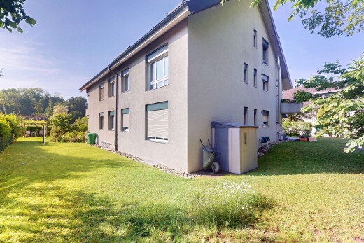 façade avec property visible, bardage en stuc, pelouse, et day time