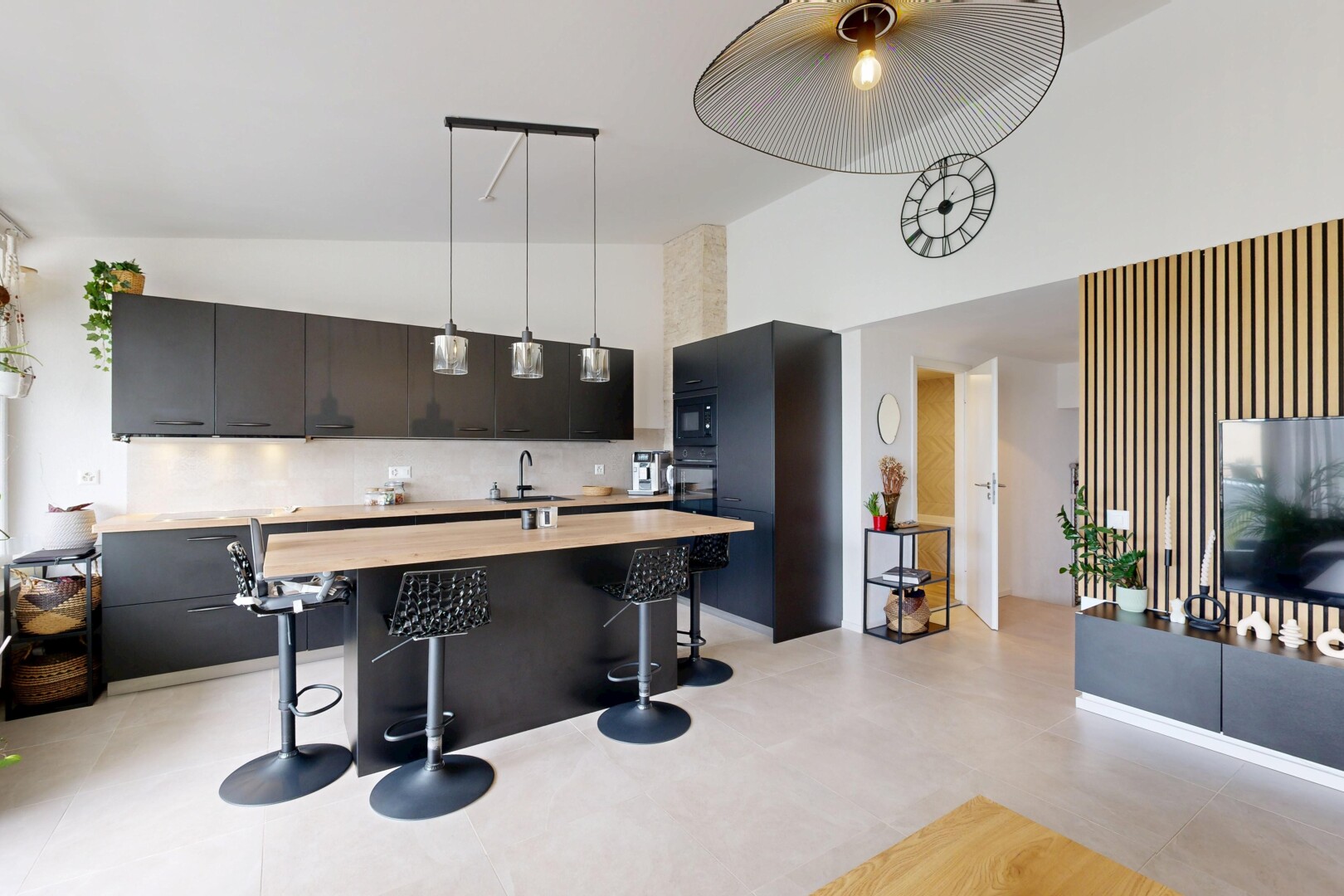 kitchen with decorative light fixtures, dark cabinetry, a high ceiling, wood counters, and a center island