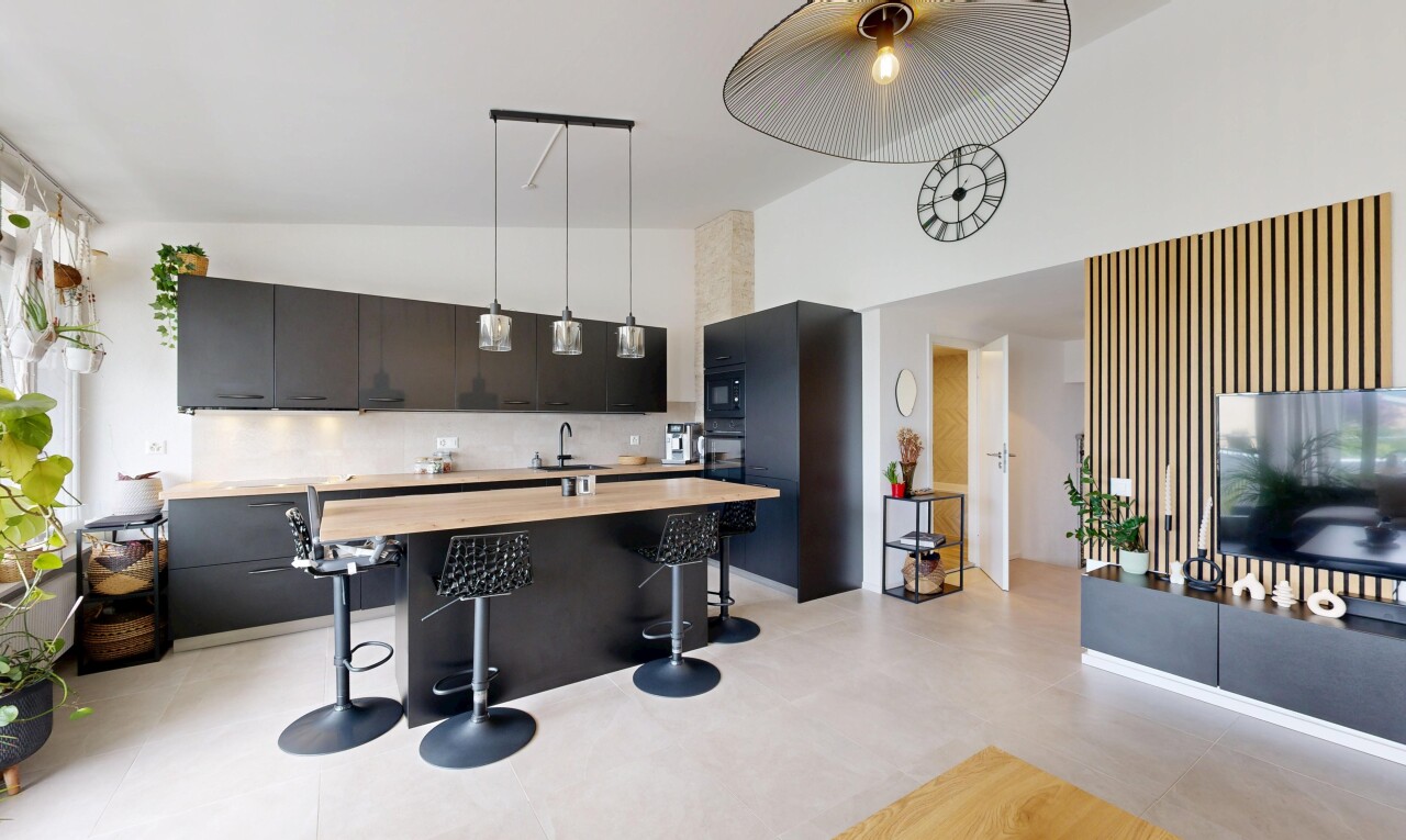 kitchen with decorative light fixtures, dark cabinetry, a high ceiling, wood counters, and a center island