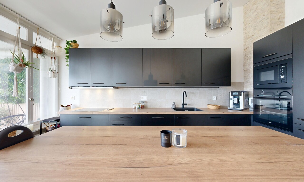 kitchen with black appliances, decorative backsplash, and decorative light fixtures