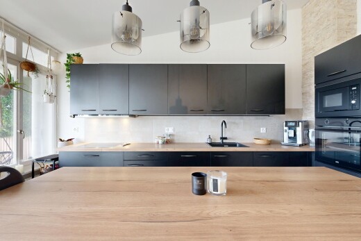 kitchen with black appliances, decorative backsplash, and decorative light fixtures