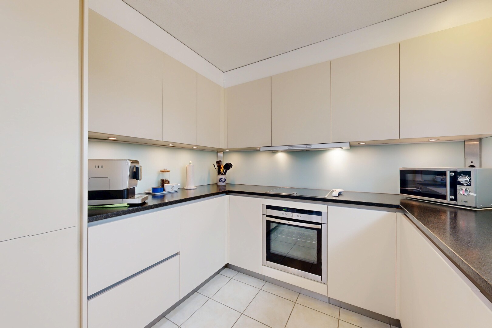 küche mit light floor, dark countertops, arbeitsplatten, ofen, und mikrowelle