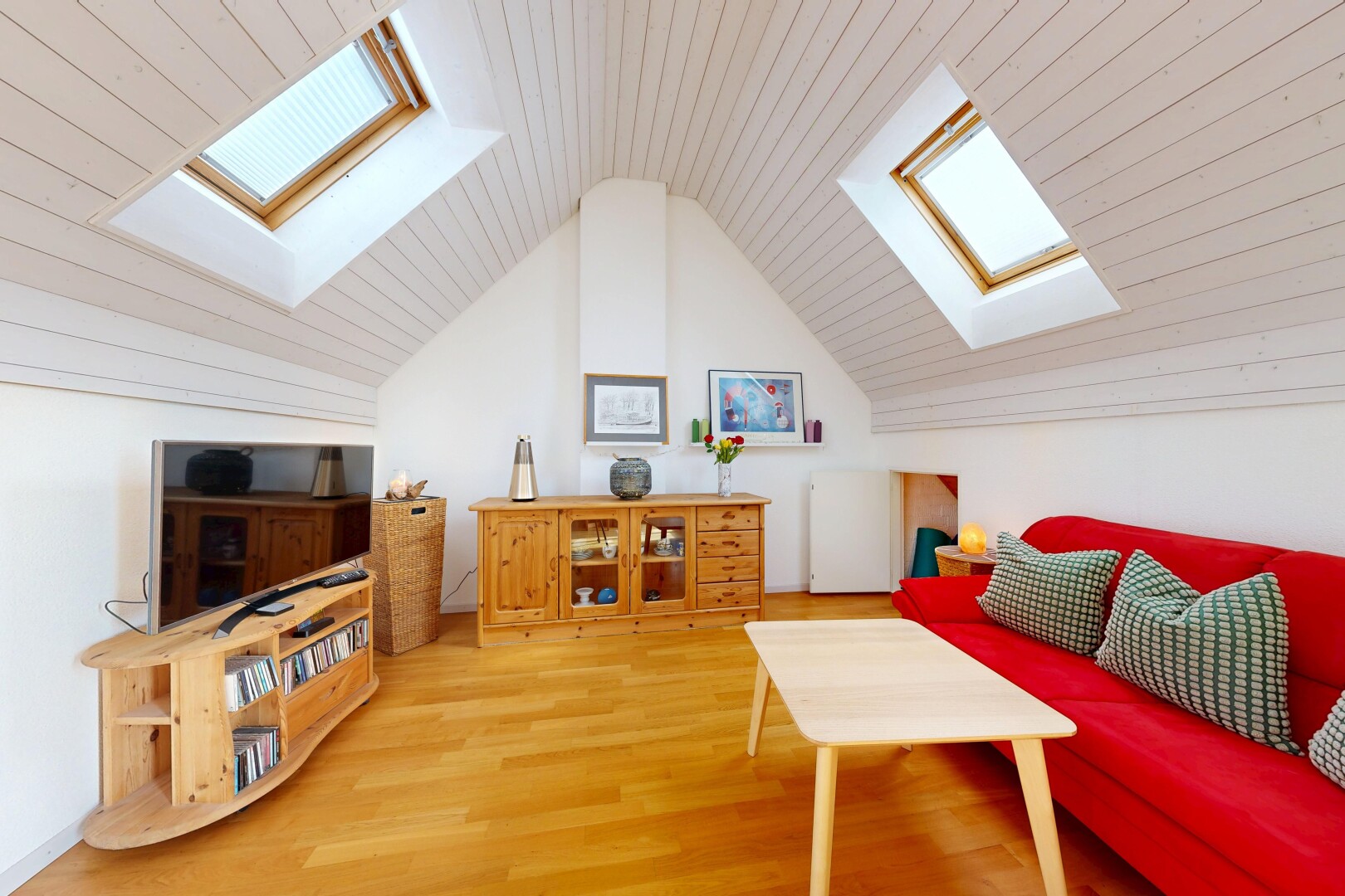 wohnzimmer mit dachfenster, zusätzliches zimmer, fernseher, wood finish floor, und holzfußboden