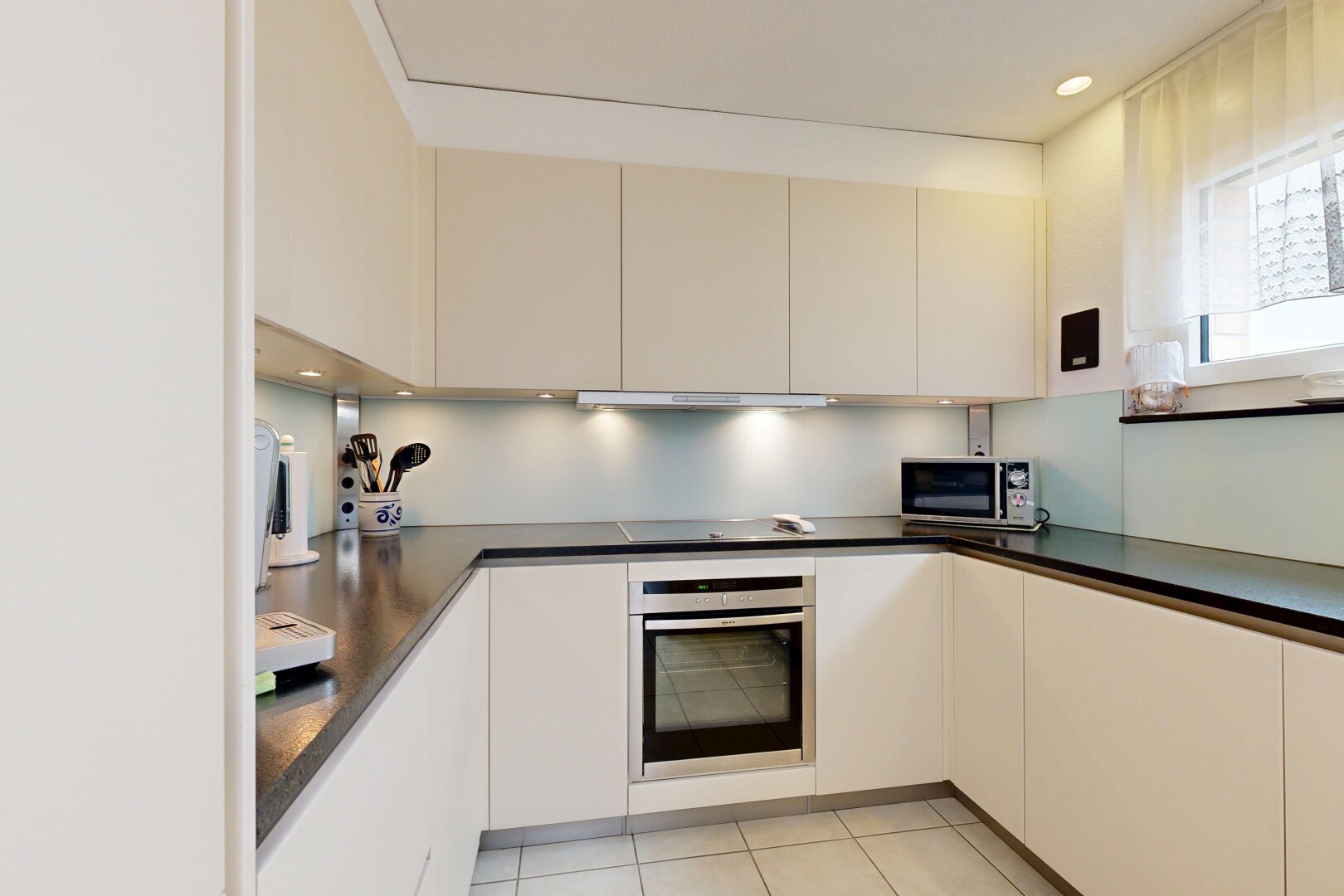 küche mit light floor, ofen, dark countertops, arbeitsplatten, und mikrowelle