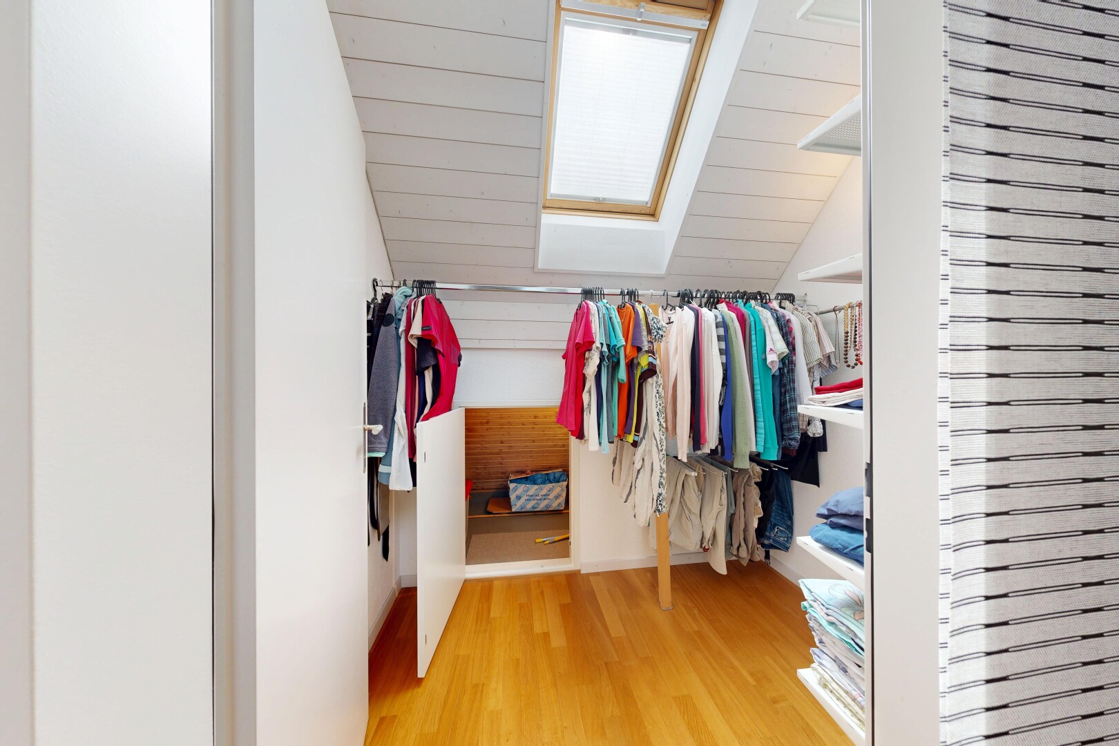 begehbarer kleiderschrank mit wood finish floor, holzfußboden, vaulted ceiling, dachschräge, und begehbarer kleiderschrank