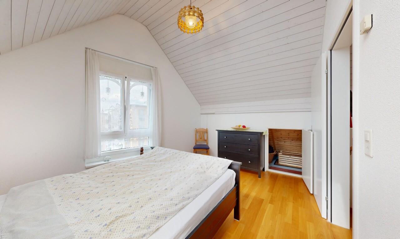 zimmer / schlafzimmer mit holzfußboden, wood finish floor, zusätzliches zimmer, pendelleuchte, und dachschräge
