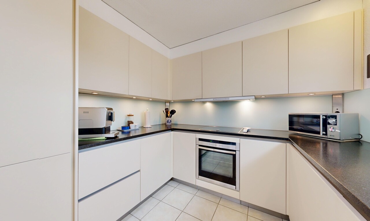 küche mit light floor, dark countertops, arbeitsplatten, ofen, und mikrowelle