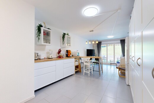 cuisine avec armoires blanches, white cabinets, light countertops, inside property, et éclairage suspendu