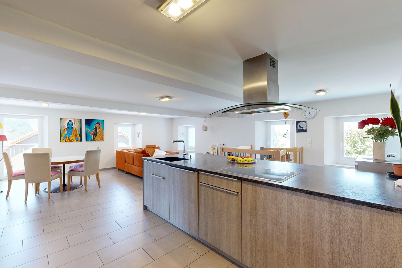 kitchen with island range hood, open floor plan, modern cabinets, wood finish cabinetry, and black electric stovetop