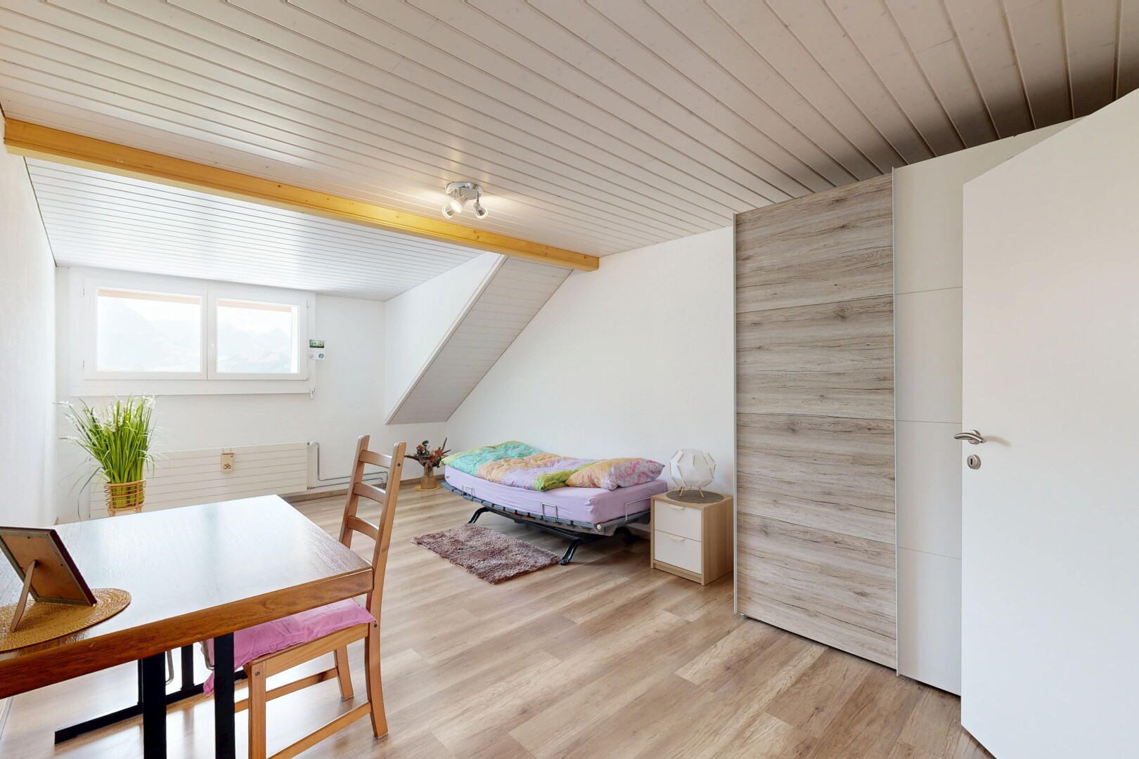 living / dining area with light wood-style floors and lofted ceiling