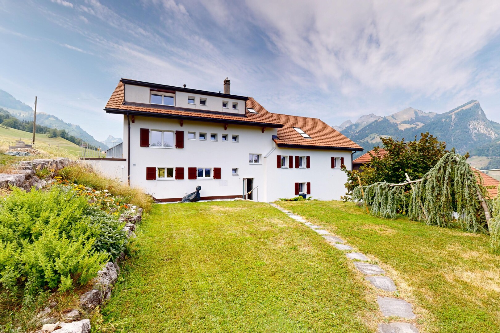 outdoor house featuring a yard, a chimney, a tiled roof, and a mountain view