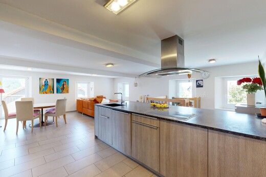 kitchen with island range hood, open floor plan, modern cabinets, wood finish cabinetry, and black electric stovetop