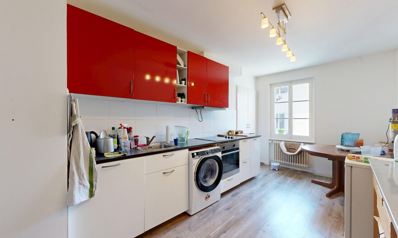 cuisine avec radiateur, dark countertops, plans de travail, lave-linge et sèche-linge, et light floor