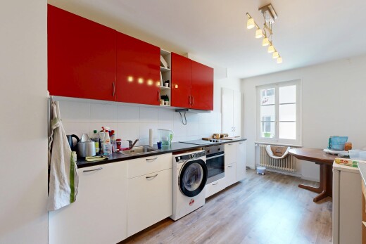cuisine avec radiateur, dark countertops, plans de travail, lave-linge et sèche-linge, et light floor
