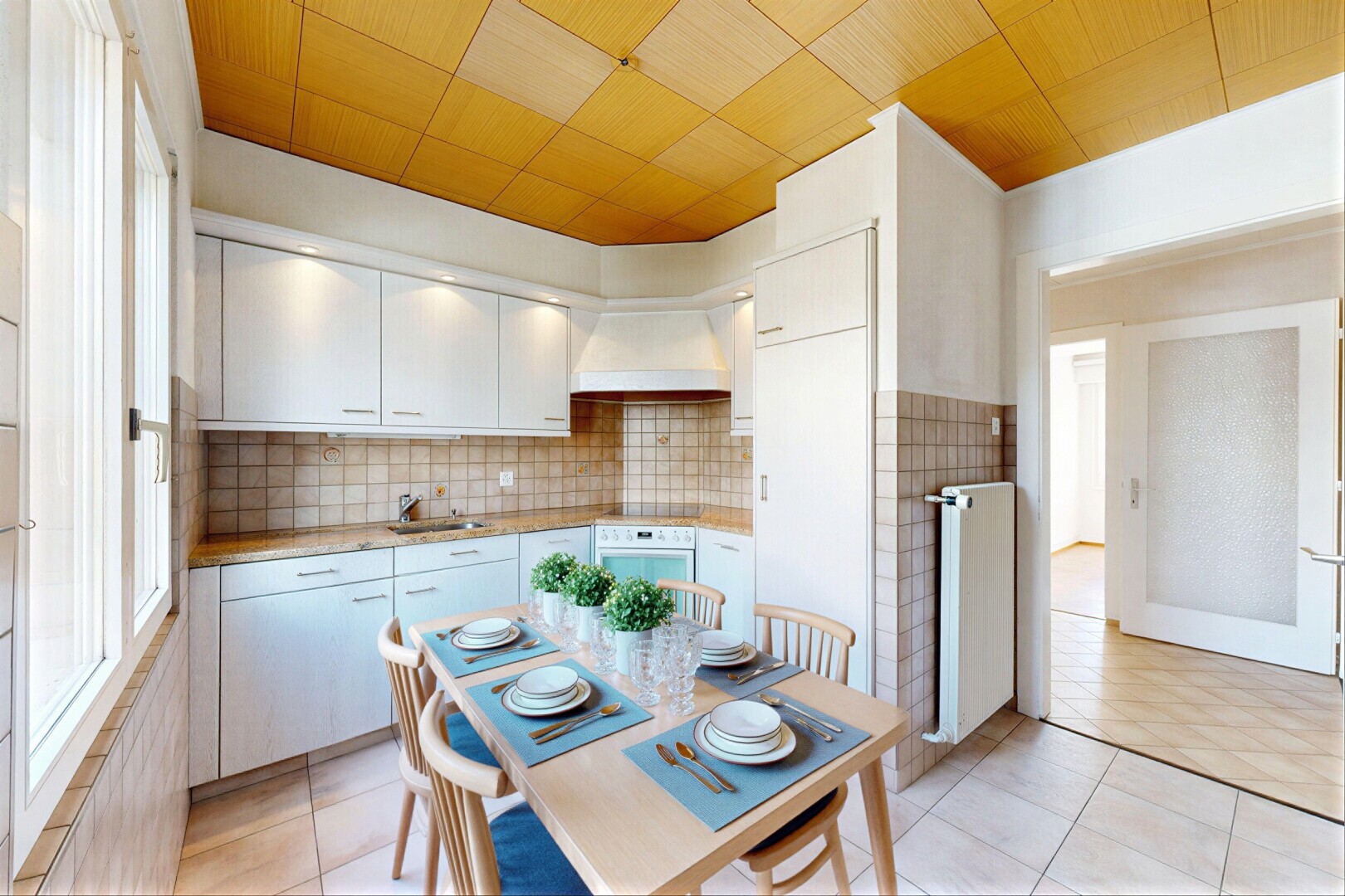 kitchen featuring light countertops, stainless steel oven, radiator heating unit, tasteful backsplash, and light tile patterned floors