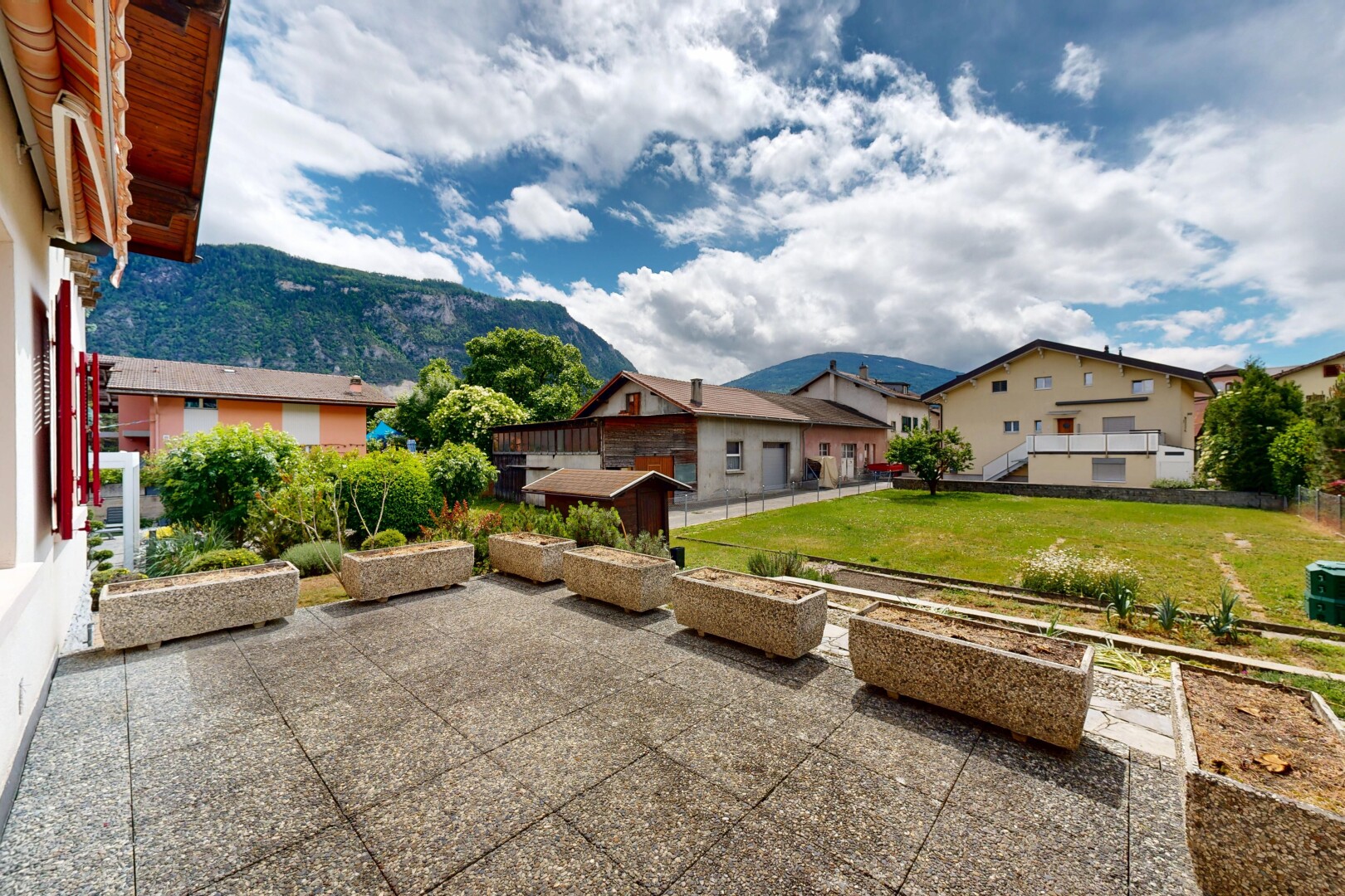 outdoor house featuring a yard, a mountain view, and a garden