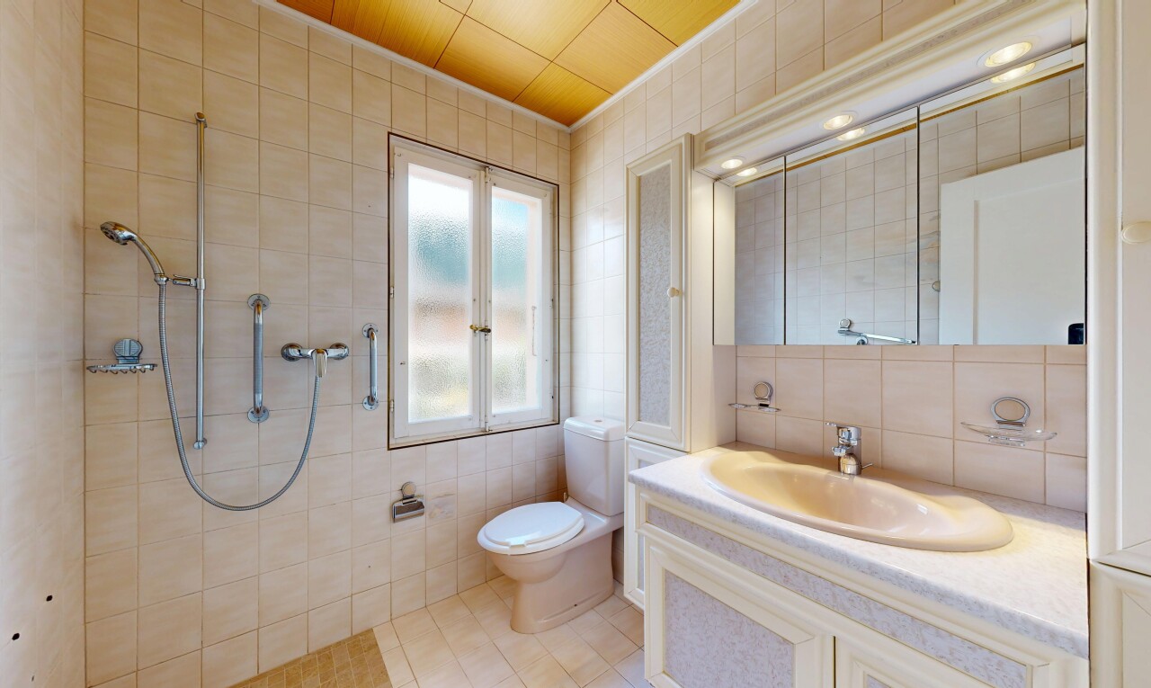full bathroom featuring tile walls, vanity, a tile shower, and light tile patterned floors