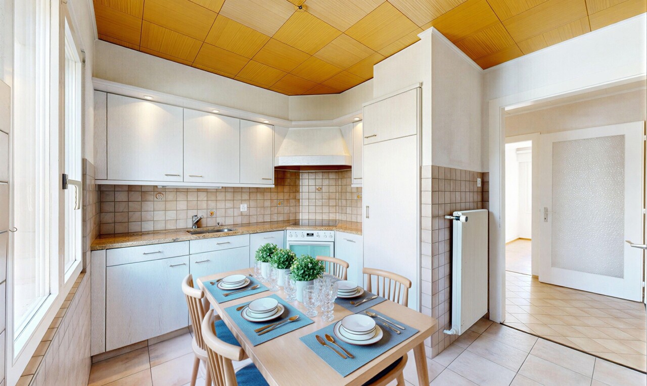 kitchen featuring light countertops, stainless steel oven, radiator heating unit, tasteful backsplash, and light tile patterned floors
