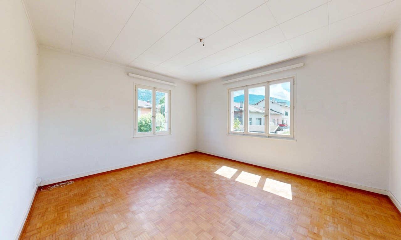 spare room featuring parquet flooring and baseboards