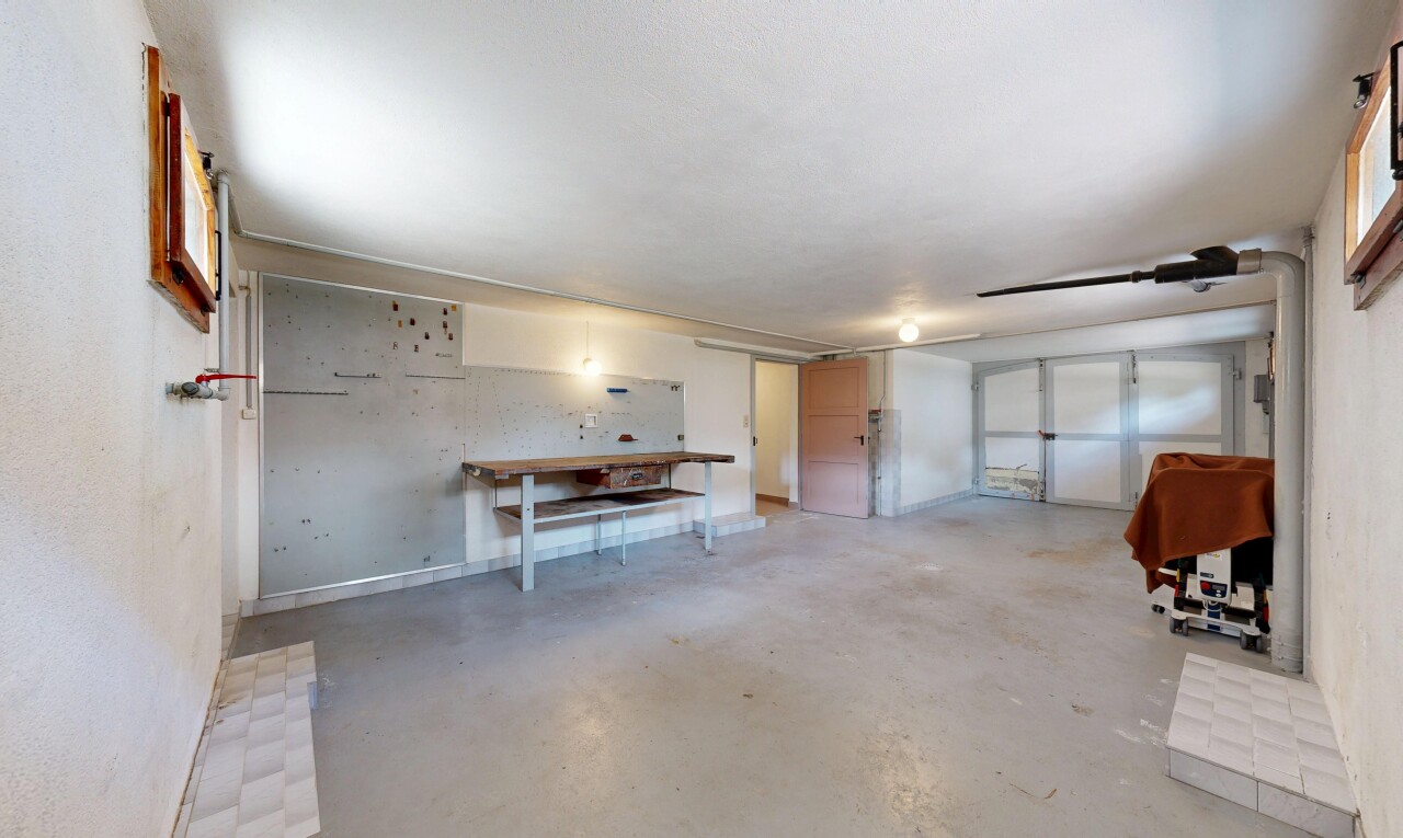 unfurnished living room with concrete flooring and a garage
