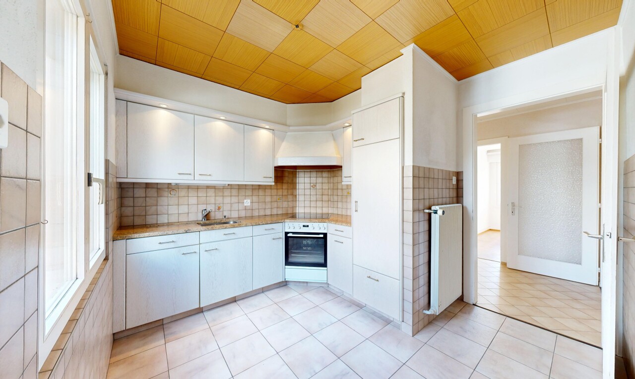 kitchen featuring light countertops, stainless steel oven, radiator heating unit, tasteful backsplash, and light tile patterned floors
